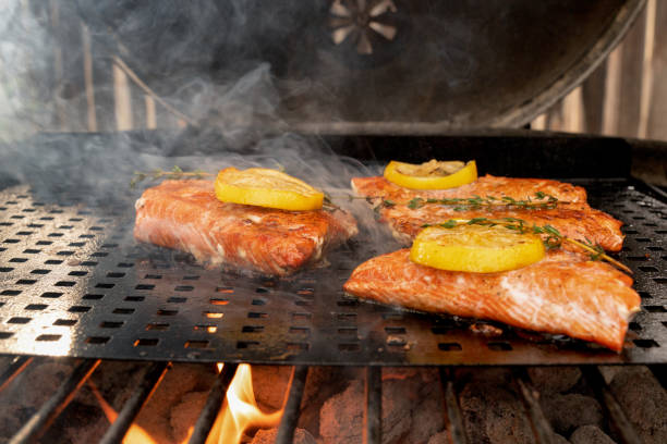 istock Delicious Salmon Filets on a grill topped with lemon slices 1058965498