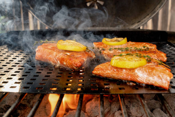 istock Delicious Salmon Filets on a grill topped with lemon slices 1058966532