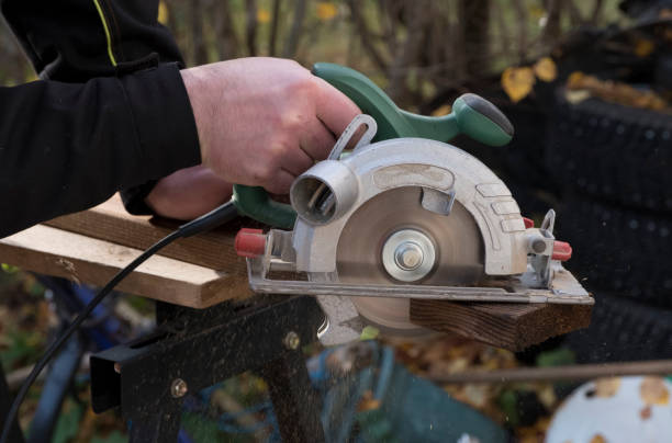 istock Construction work, a carpenter saws a disk of burnt wooden boards. 1058966990