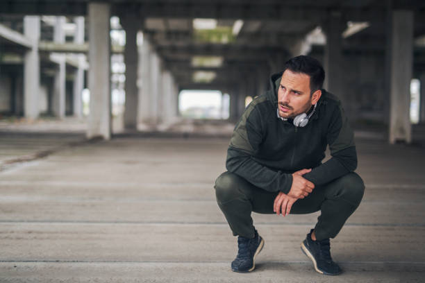 runner catching breath - bending knees imagens e fotografias de stock