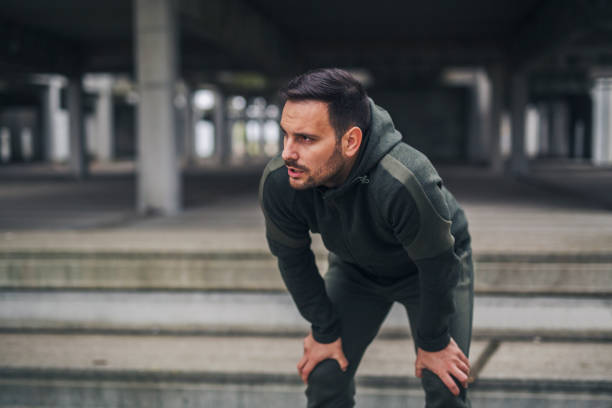 Runner catching breath Fit young runner catching his breath during training running to catch the train stock pictures, royalty-free photos & images