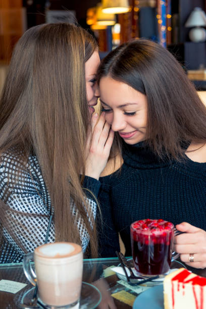 istock Girlfriends in a cafe gossip and drink coffee 1058986020