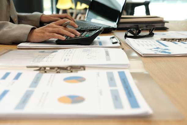 istock financial adviser working with calculator & computer. accountant doing accounting & calculating revenue & budget. finance & economy concept 1058986282