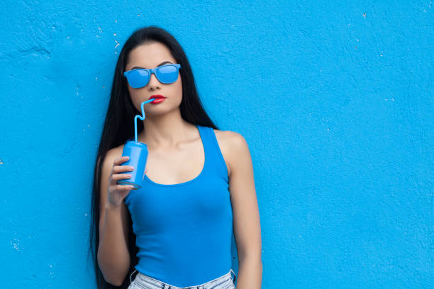 istock Woman in blue outfit drinking blue drink 1058986418