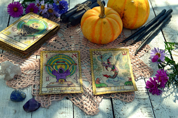 Still life with pumpkins, tarot cards and black candles on old napkin with embroidery stock photo