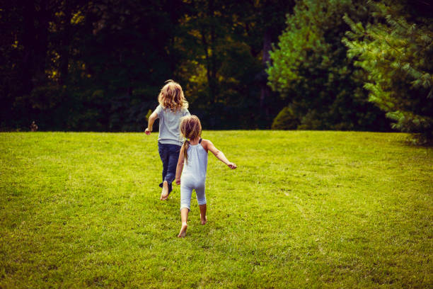 jugar todo el día - child running playing tag fotografías e imágenes de stock