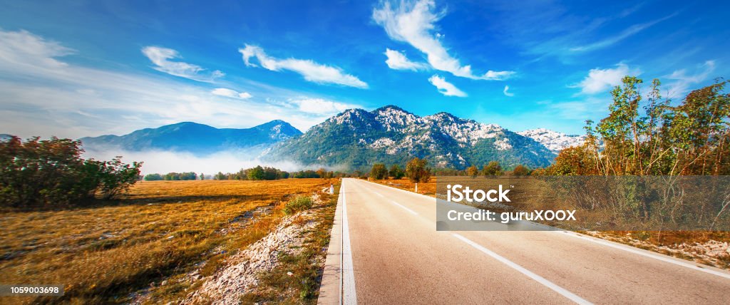 Highway through a desert landscape with mountains in background Highway through a desert landscape with mountains in background. Dragalj, Montenegro Adventure Stock Photo