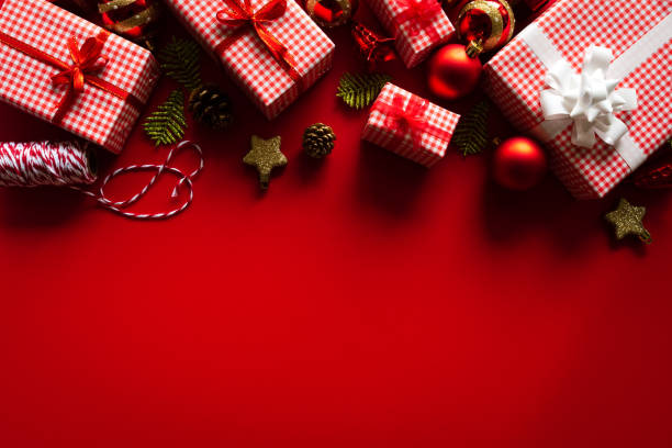 istock Christmas background concept. Christmas gift box with red ball and pine cones on red background. 1059007962