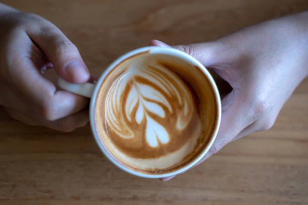 istock women  Holding coffee cup, wooden table  cafe while having coffee 1059026132
