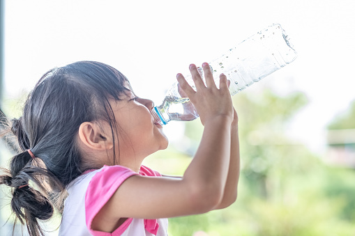 little girl drinking water from a bottle