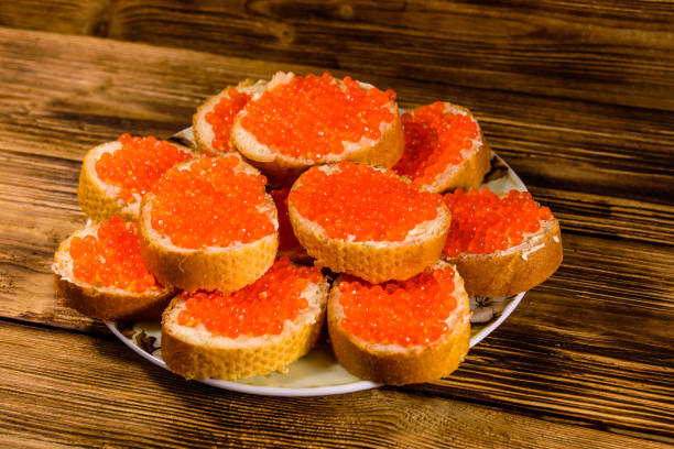 istock Sandwiches with red caviar on wooden table 1059030094