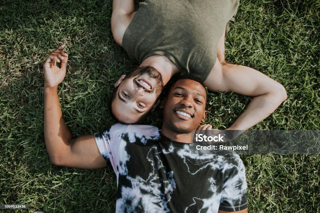 Gay couple relaxing in the grass Couple - Relationship Stock Photo