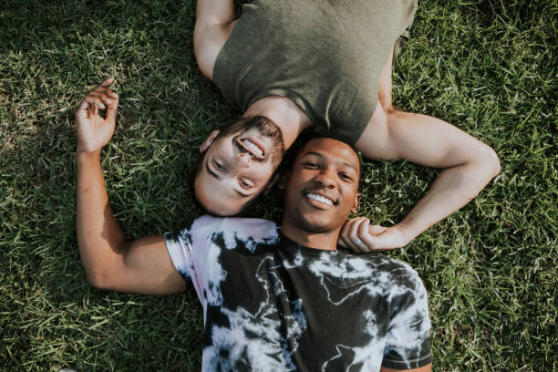 Gay couple relaxing in the grass Gay couple relaxing in the grass stubble male african ethnicity facial hair stock pictures, royalty-free photos & images