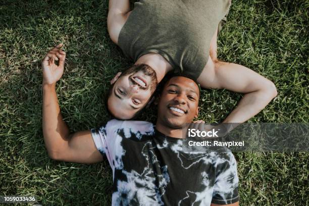 Gay Couple Relaxing In The Grass Stock Photo - Download Image Now - Couple - Relationship, LGBTQIA People, Gay Couple