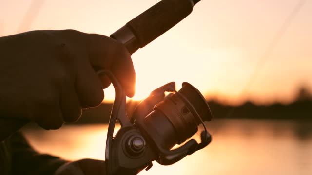 Close-up of friction reel fishing rod on the background of a beautiful sunset.