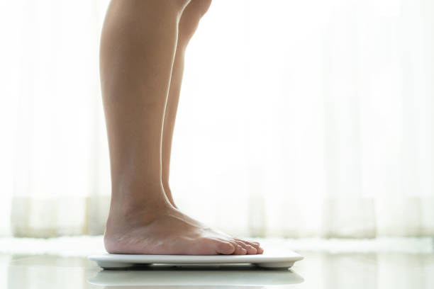 istock young woman standing on digital weight scale 1059039378