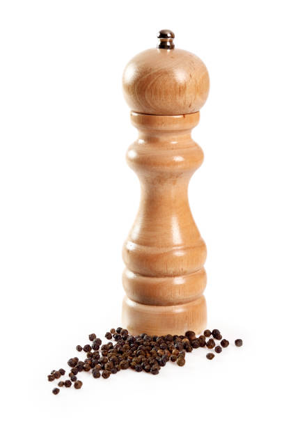 istock Wood Pepper Mill with black peppercorns. Isolated with clipping path. 1059041086