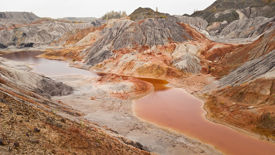 Quarry for the extraction of clay in Russia. Martian landscapes-red-orange river and hills