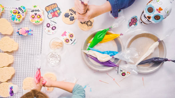 istock Mother and daughter decorating sugar skull cookies 1059046254