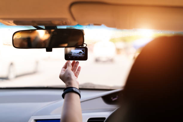 istock Front camera car recorder, woman set video recorder next to a rear view mirror 1059046294