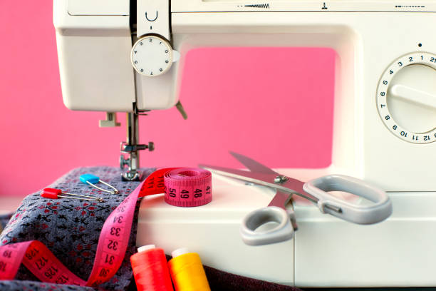 máquina de costura e pano sobre um fundo rosa. - tailor tape measure instrument of measurement textile - fotografias e filmes do acervo