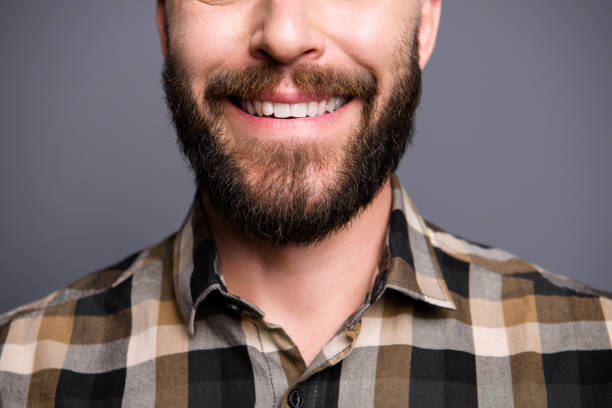 close up half face photo of man beaming toothy smile isolated on gray background - half smile imagens e fotografias de stock