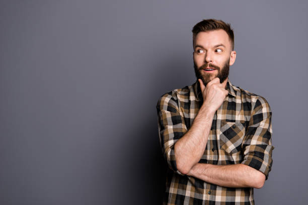 istock Young emotional careless man isolated on gray background with copy space for text put his head on his fist and look aside stand in casual outfit 1059055708