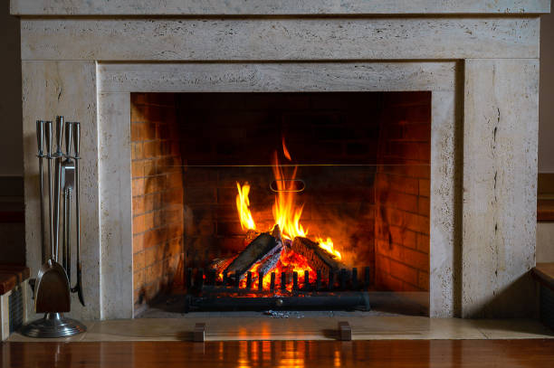 Burning fireplace. Fireplace as a piece of furniture. Christmas New Year concept decoration. Wood burning in a cozy fireplace at home in interior. Fireplace as a piece of furniture. Christmas New Year concept decorations. fireplace stock pictures, royalty-free photos & images