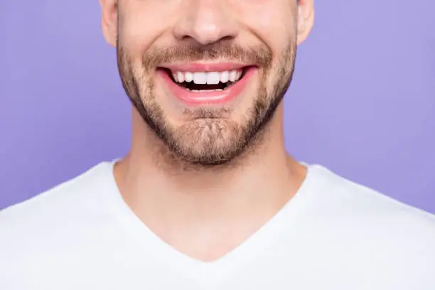 Close-up cropped portrait of attractive, trendy, stylish, toothy man with wide beaming smile and healthy teeth, over pastel violet purple background