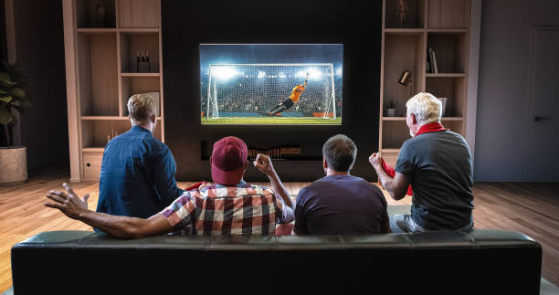 gruppe von fans beobachten fußball kurz auf den fernseher und feiert ein ziel, auf der couch im wohnzimmer sitzen. - zimmer bildschirm stock-fotos und bilder