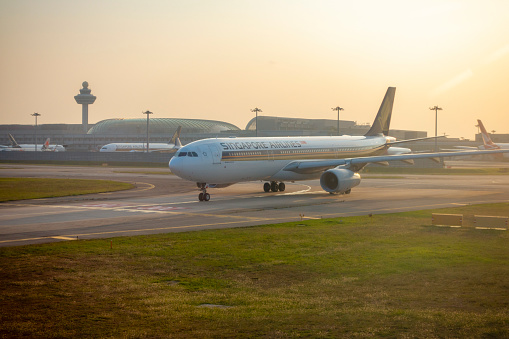 Singapore Airlines aircraft at Changi Airport in Singapore during sunrise.