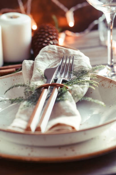 istock Decorated Thanksgiving or New Year table setting among white candles and winter decor. The concept of a festive dinner. 1059082942