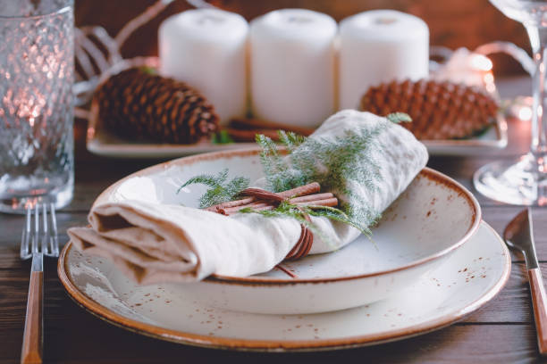 istock Decorated Thanksgiving or New Year table setting among white candles and winter decor. The concept of a festive dinner. 1059083098