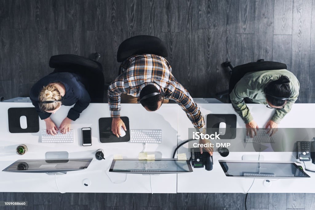 We'll ensure your query gets answered High angle shot of a group of call centre agents working in an office Technology Stock Photo