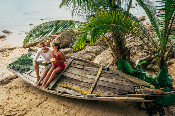 пара на берегу райского острова - tropical hotel стоковые фото и изображения