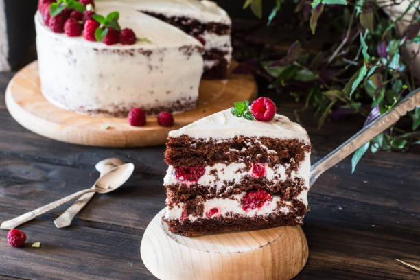 istock Portion of layered creamy fruit cake with in close up view. Raspberry cake with chocolate. Chocolate cake. Mint decoration. Cheesecake on wooden table. Still life of food. Black forest cake 1059094208