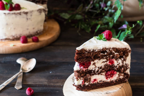 istock Portion of layered creamy fruit cake with in close up view. Raspberry cake with chocolate. Chocolate cake. Mint decoration. Cheesecake on wooden table. Still life of food. Black forest cake 1059094276