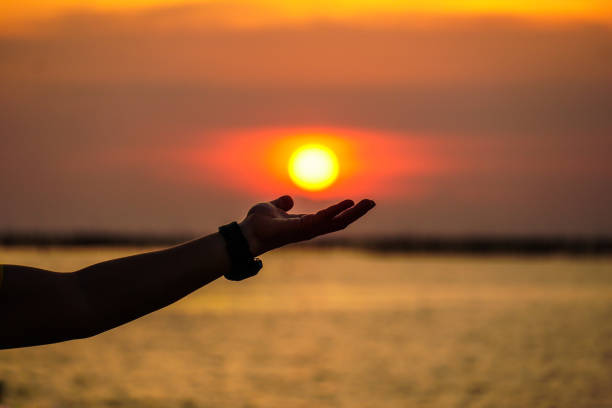istock Sunset with the sun resting on the palm of a hand 1059094678