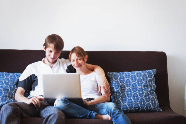 istock Young family couple using laptop computer at home. 1059097442