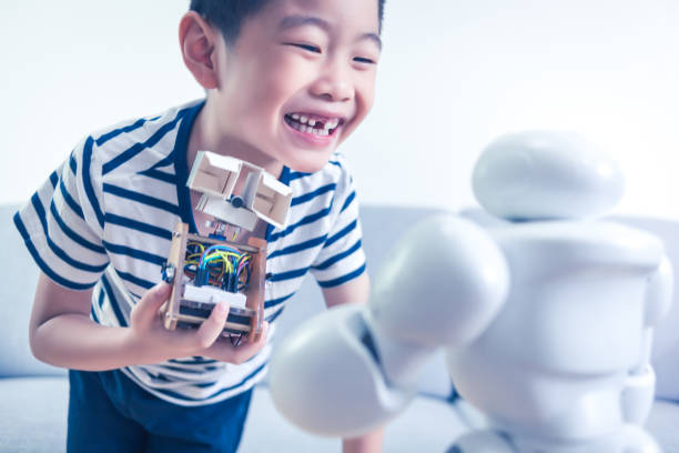 Little scientist showing his own robot indoors