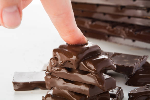 istock Woman hand is pressing melting stack of chocolate, hate chocolate concept 1059099676