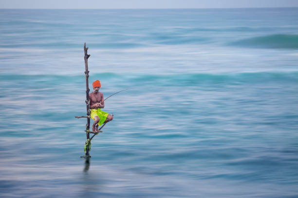 Galle, Sri Lanka - September 26, 2018: Fisherman on stilts in the Indian Ocean, in Galle, Sri Lanka.