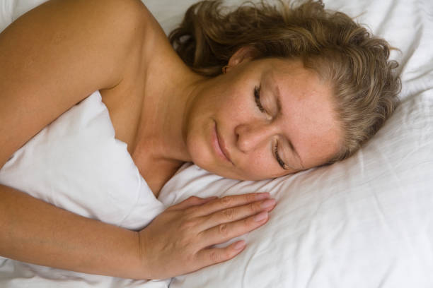 istock Pretty woman sleeping in bed under the covers. 1059102756