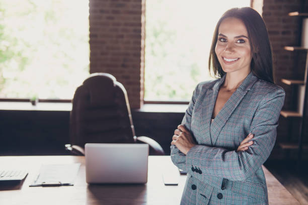 istock Elegant nice charming classic trendy cheerful lady boss with folded crossed hands, wearing grey blazer, jacket, suit at modern loft work place, station 1059107644