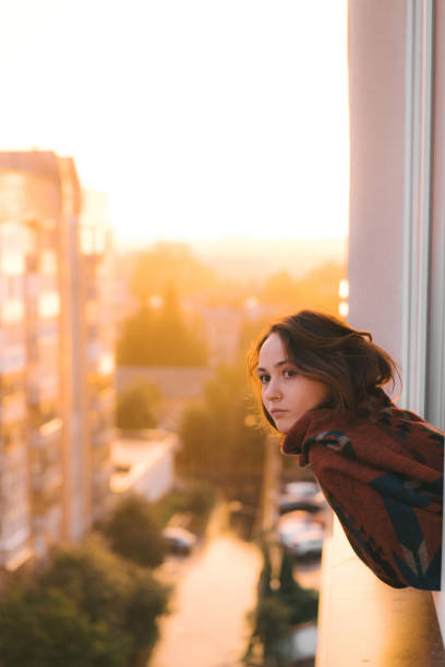 istock Woman looking from balcony  at sunset 1059107816