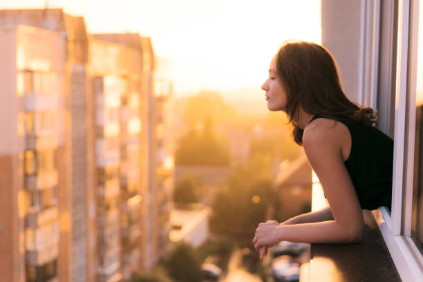 istock Woman looking from balcony  at sunset 1059107854