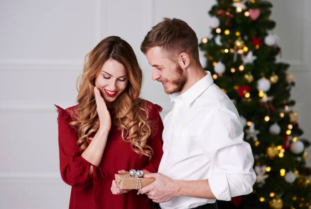 istock Man giving a christmas present to woman 1059108342