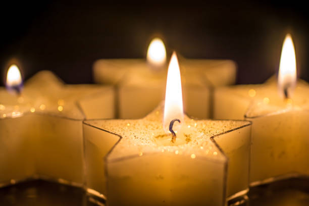 istock Four candles for the fourth advent in front of a black background 1059108384