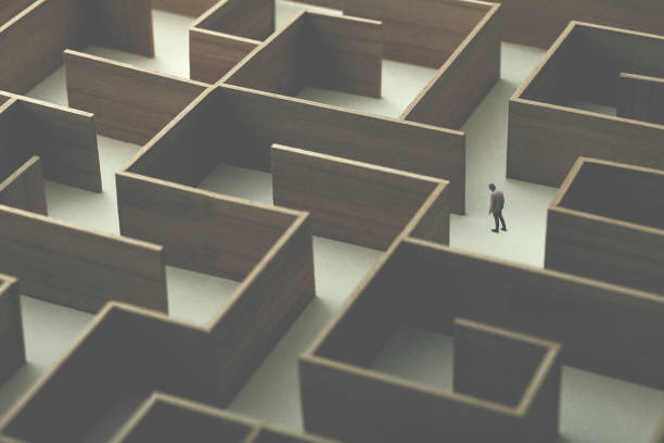 man walking in a complex maze, surreal concept stock photo