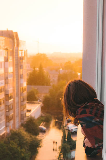istock Woman looking from balcony  at sunset 1059110410